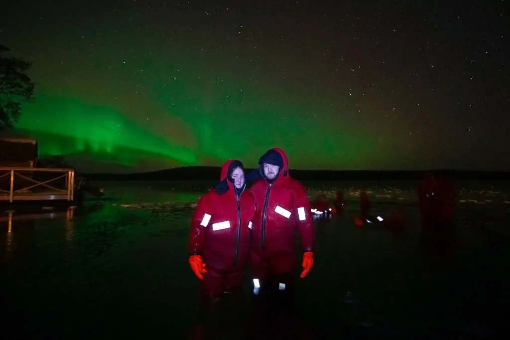 Finlandia: Vista sul lago dell'aurora boreale con tuta galleggiante